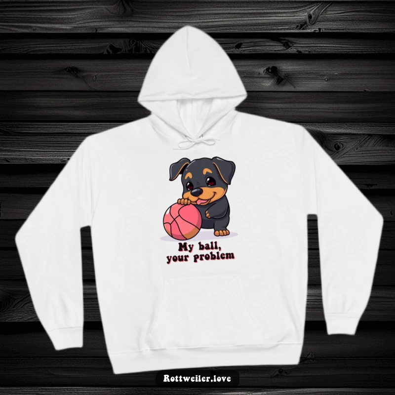 Funny Rottweiler hoodie featuring a dog playfully nudging a large, bouncy ball, perfect for staying warm and showing off your love for energetic pets.